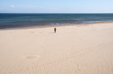 Man Walking Towards the Ocean on Brackley Beach Prince Edward Island