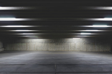 A view of a empty parking lot under the light of the garage on the city night life. 