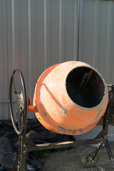 Photo concrete mixer installed on the construction site next to a pile of sand and gravel.