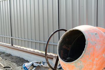 Photo concrete mixer installed on the construction site next to a pile of sand and gravel.