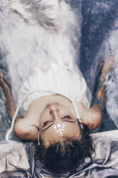 portrait of beautiful woman lying in water with fabric. Fashion concept