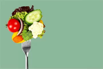 Poster Fresh raw vegetables on fork on blue background © BillionPhotos.com