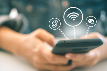 Working woman using personal smartphone in workplace to connect internet to communication with wifi , mail, chat icon backgroun. Business technology concept.