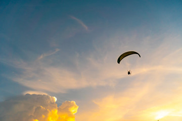 Man is riding para motor in beautiful  sunset cloud sky background.