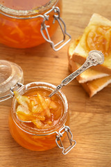 Toasts and orange jam in a glass jar