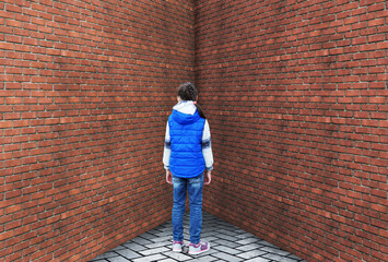 Punished little girl is standing in a corner