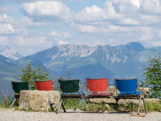 Fototapeta na wymiar Bunte Stühle vor Bergkulisse im Allgäu