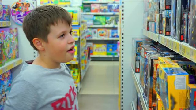 Boy 10-12 years chooses toys. Children's toy store