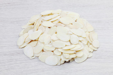 Heap of almond flakes on wooden background     