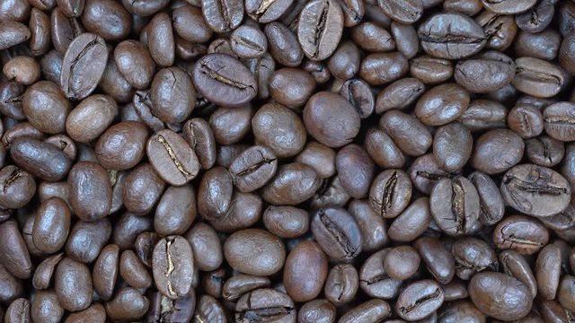 Fried coffee beans background, close up, rotation loopable 4k top view. Food  background. Gastronomy concept, organic food. Macro coffee beans