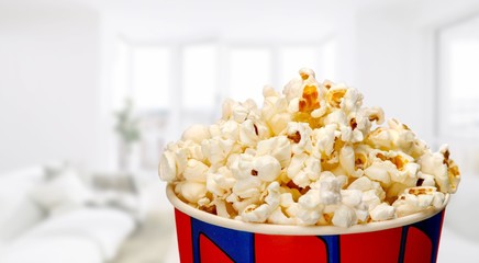 Bucket with popcorn on blurred background