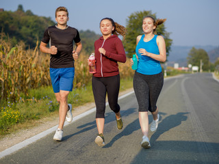 young people jogging on country road