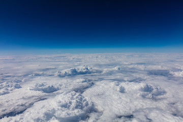 Naklejka premium Cloudscape background. View out of an airplane window.