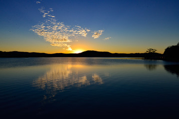 Obraz premium Sunset and highlighted clouds reflection in calm lake