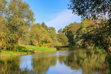 Fototapeta na wymiar River landscape on a background of blue sky at sunny autumn morning