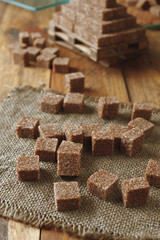 cataract of brown sugar cubes on wooden background