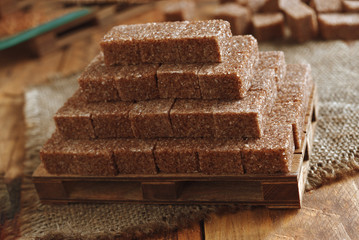 golden pyramid of brown sugar cubes on wooden background