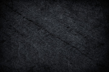 Dark grey / black slate background or texture.