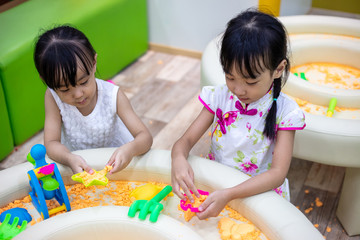Fototapeta premium Asian Chinese Little Sisters Playing Kinetic Sand