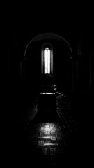 Altar illuminated by a window in a church in tuscany in black and white