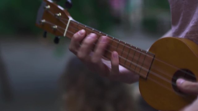 Young girl plays ukulele for her partner