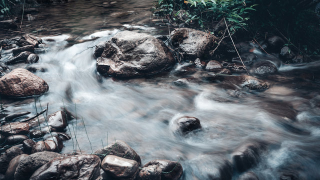 Flowing water through the stones along the Serse's river side in summer rainy day
