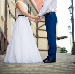 Newlyweds joined hands in an old street