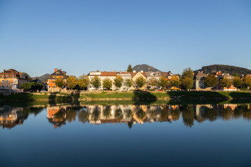 Fototapeta na wymiar Im Fluss spiegelnde Wohnhäuser im Herbst, Farben