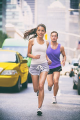 City runners - urban new yorkers people running in busy street in New York NYC. Young adults asian...