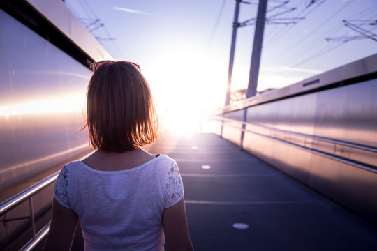 Junges Mädchen blickt dem Sonnenuntergang entgegen, urban; Selbstbewusstsein