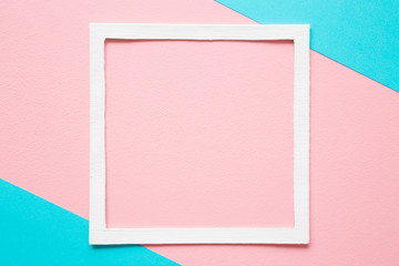 White frame on pastel pink and turquoise blue paper background. Soft light color. Greeting card. Mockup for positive idea. Empty place for inspirational, emotional, sentimental text, quote or sayings.