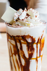 Close up Caramel milkshake topping with whip cream and chocolate powder.