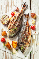 Grilled seabream and potatoes with herbs and tomatoes