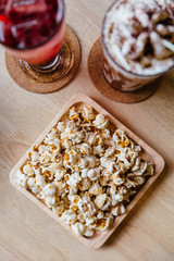 Top view of Salted popcorn served in square wooden plate on wooden table. 