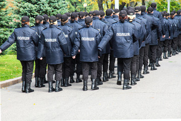 The policemen in uniform with the inscription Police in Ukrainian,  stand the street in Dnipro city, Dnepropetrovsk, Ukraine