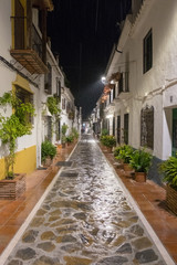 spanish narrow street in old town in the rain