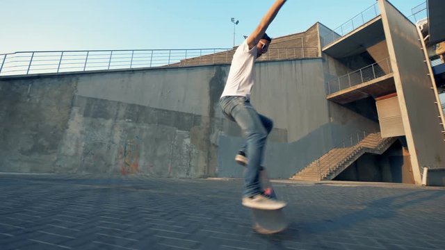 Young active sportsman jumps on a skateboard, side view.