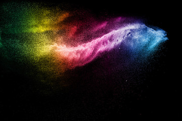 Freeze motion of color dust particles on black background.Abstract color powder overlay texture.