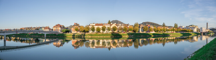 Fototapeta na wymiar Im Fluss spiegelnde Wohnhäuser im Herbst, Farben, Panorama