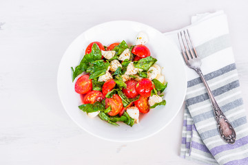 Italian food - Healthy caprese salad with mini mozzarella, cherry tomatoes and basil