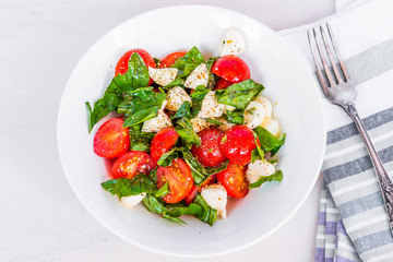 Italian food - Healthy caprese salad with mini mozzarella, cherry tomatoes and basil