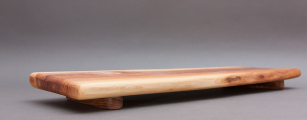 Ecological handmade wooden cutting board on grey background