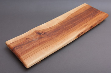 Ecological handmade wooden cutting board on grey background