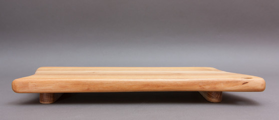Ecological handmade wooden cutting board on grey background