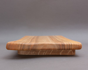 Ecological handmade wooden cutting board on grey background