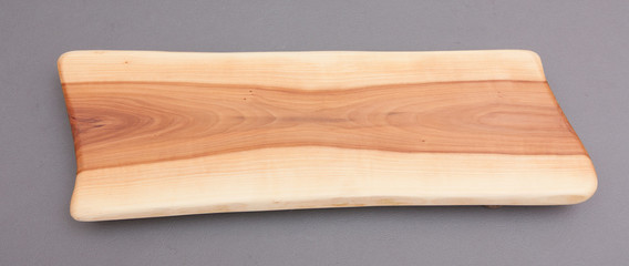 Ecological handmade wooden cutting board on grey background