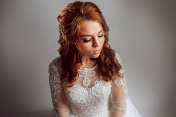 Portrait of a charming red-haired bride, Studio, close-up. Wedding hairstyle and makeup.