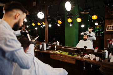 Handsome bearded man at the barbershop, barber at work.