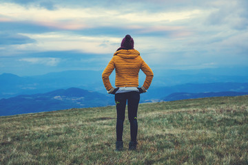 Woman standing on a empty mountain meadow.