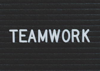 Word teamwork written on the letter board. White letters on the black background. Business concept